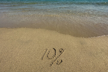 10% is written on the sand. Vacation discounts. Vacation at sea. Soft focus