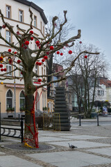 Trees in the city decorated. Jelenia Gora, Poland. Red ornaments on the trees.