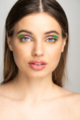 Obraz premium Brunette teen girl with creative makeup looking at camera isolated on grey.