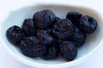 Dried prunes on white background