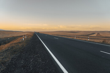 Asphalt road going through the fields