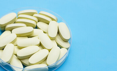Fototapeta na wymiar Vitamin C pills on blue background.