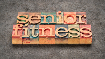 senior fitness word abstract in letterpress wood type against textured bark paper, aging and exercise concept