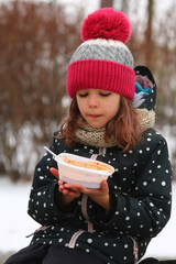 Girl eating free borscht in the Irpin park from the Point of Invincibility and volunteers because...