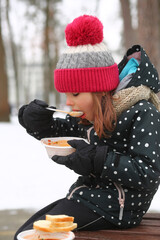 Girl eating free borscht in the Irpin park from the Point of Invincibility and volunteers because...