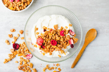 Granola with Yogurt in a Boal, Healthy Breakfast, Muesli with Dried Berries on Bright Concrete Background
