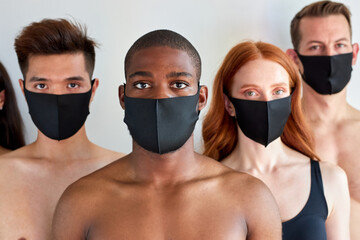 Group of people with protective mask stand looking at you isolated on white background, concept of protection from flu A-H1N1 coronavirus omicron. portrait of diverse people. black male in center