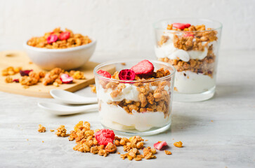 Granola and Yogurt Parfaits, Healthy Breakfast or Snack, Muesli with Dried Berries on Bright Concrete Background