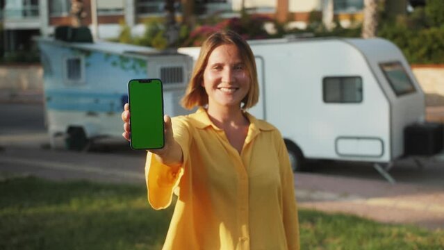 Green Screen chroma key Handheld Smartphone. Travel with phone concept, application mock up. Sunset on a tropical beach.