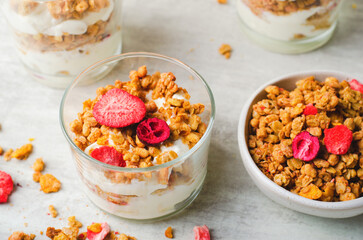 Granola and Yogurt Parfaits, Healthy Breakfast or Snack, Muesli with Dried Berries on Bright Concrete Background