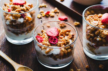 Granola and Yogurt Parfaits, Healthy Breakfast or Snack, Muesli with Dried Berries on Wooden Background