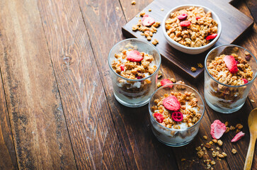Granola and Yogurt Parfaits, Healthy Breakfast or Snack, Muesli with Dried Berries on Wooden Background