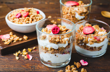 Granola and Yogurt Parfaits, Healthy Breakfast or Snack, Muesli with Dried Berries on Wooden Background
