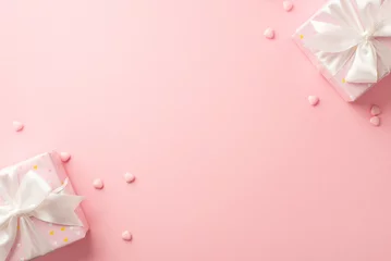 Fotobehang St Valentine's Day concept. Top view photo of stylish present boxes with white ribbon bows and heart shaped sprinkles on isolated pastel pink background with blank space © ActionGP