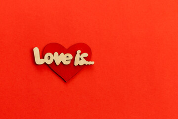 Decorative heart with lettering Love is on red background, flat lay concept of Valentine's Day.