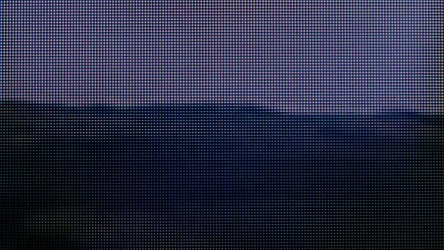 Macro view of a television LCD screen at the time of broadcasting a TV program. Close-up of the monitor pixels. Red, blue and green sub-pixels create an image on the screen. VA matrix of 4K TV.