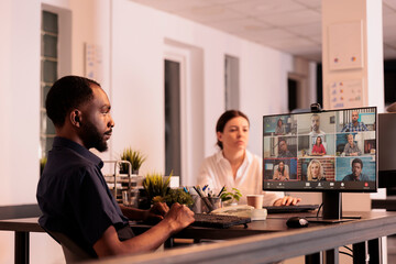 Employee talking with colleagues on online meeting, having conversation on corporate videocall. African american man discussing startup plan on teleconference, telecommuting