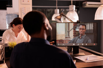 Employee talking with project manager speaking on corporate videocall on computer, discussing company strategy on webcam teleconference. Team leader listening to colleague on videoconference
