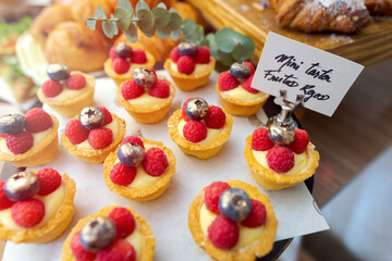 Close up of little cheesecakes with blueberries and  raspberries on top. Little berry pies.