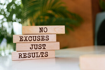 Wooden blocks with words 'No excuses just results'.