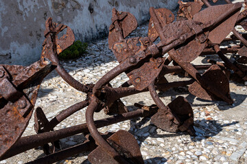 Iron anchors once used for the positioning of the tuna trap are now exhibited in the square of the former Tonnara di Scopello.