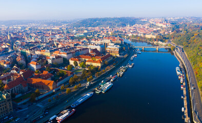 Fototapeta premium Aerial view of modern Prague cityscape overlooking bridges over Vltava river on sunny autumn day, Czech Republic