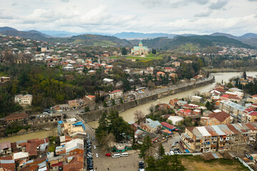 Scenic aerial view of Kutaisi cityscape on banks of Rioni River in spring overlooking medieval Bagrati Cathedral, Imereti region, Georgia.