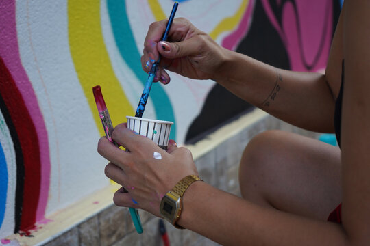 wall painting, Beautiful woman in black t-shirt painting the wall colorfully