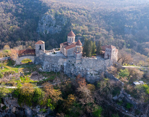 Fototapeta na wymiar Scenic view from drone of architectural complex of Motsameta Monastery on rock in mountainous region of Imereti in Georgia in springtime.
