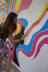 wall painting, Beautiful woman in black t-shirt painting the wall colorfully