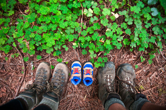 Expecting parents use a pair of small hiking boots in line with their own to announce the arrival of their new baby.