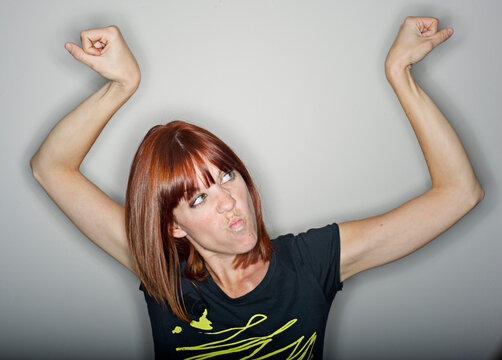 A woman flexes her arms.