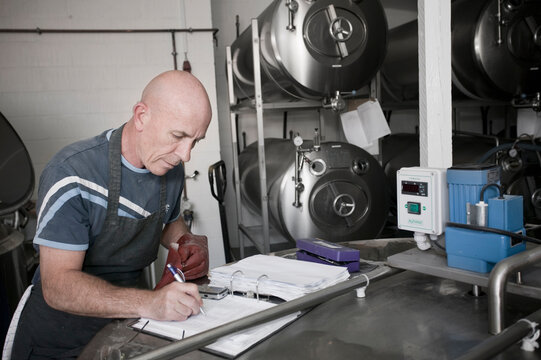 The brewmaster of a small brewery in Raervig, Denmark, takes notes.