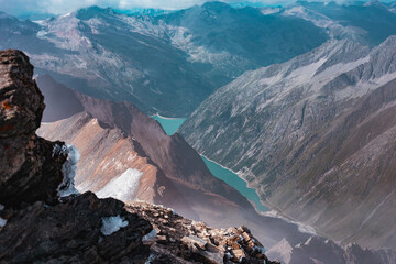 View from the top of the Alps Mountain to the valley with a lake