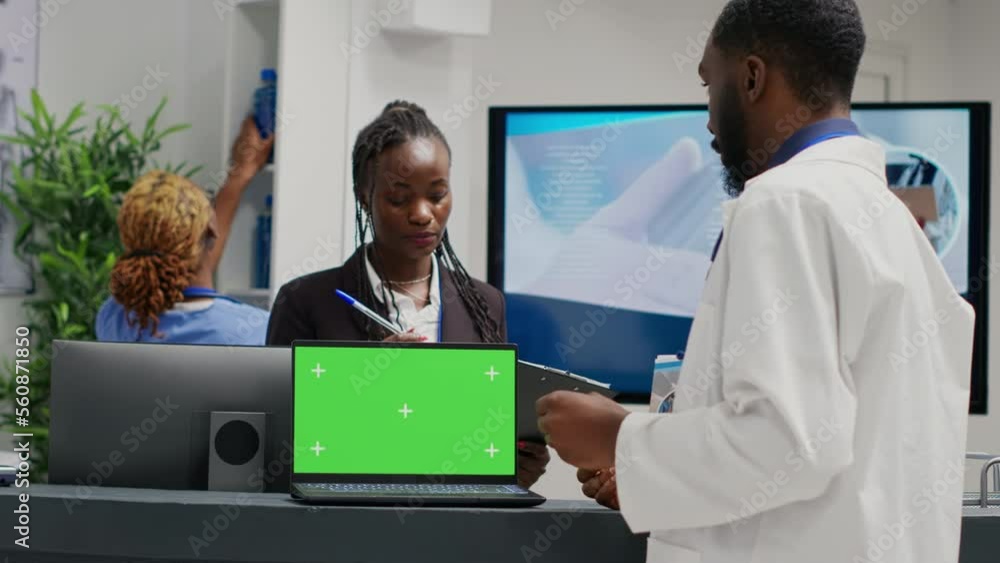Poster medical specialists working at reception with greenscreen on laptop, using checkup form papers in he