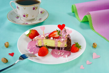 Piece of cheesecake decorated with strawberries, Valentines Day dessert, hearts in pistachio cheesecake with a slice of strawberry, with pink icing and pastry sprinkles on a white plate, close-up.