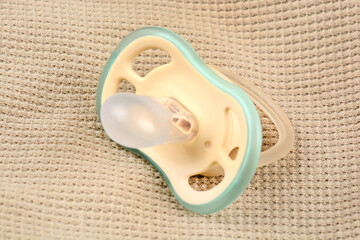 Orthodontic pacifier on a beige background