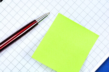 Empty green note on a notepad with pen