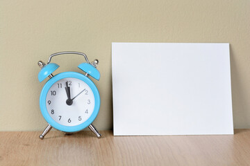 Empty paper with alarm clock on desk