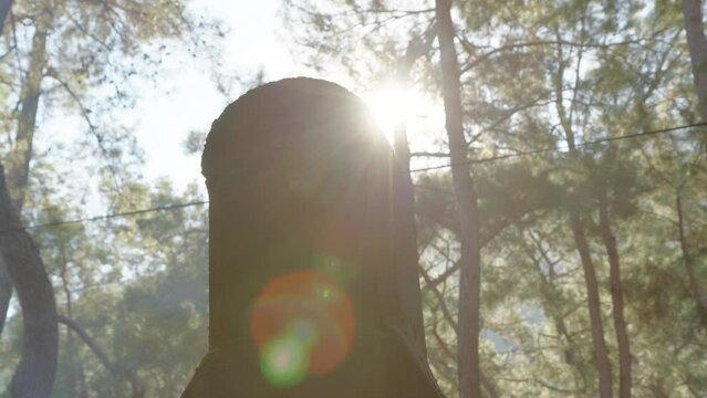 black chimney of crematorium works in forest and white smoke comes out of it. Sun shine in camera. concept of end of life and beginning of new one. Smoke rises up wind from stone black pipe in soot.