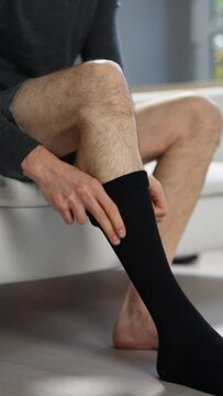 Man Putting On Medical Compression Stockings
