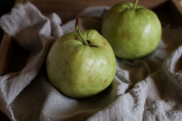 Guava fruit with leaf on white wooden dark background. Fresh organic Tropical high vitamin C fruit, Healthy eating.