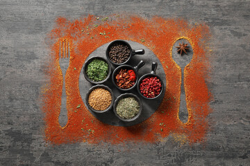 Different spices, silhouettes of cutlery and plate on grey table, flat lay