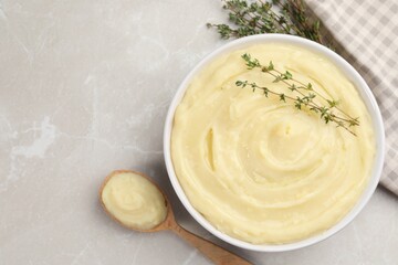 Bowl of tasty mashed potato with rosemary on grey marble table, flat lay. Space for text