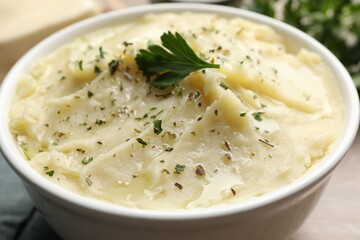 Bowl of delicious mashed potato with parsley, closeup