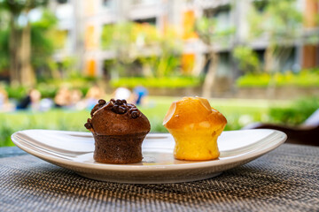 Chocolate and almond muffins lie on a white plate, homemade bakery for breakfast 