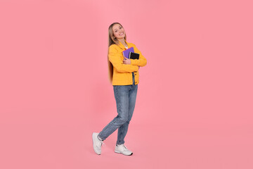 Naklejka premium Teenage girl with notebooks on pink background