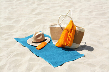 Blue towel, bag and accessories on sandy beach