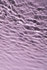Closeup view of water with rippled surface on violet background