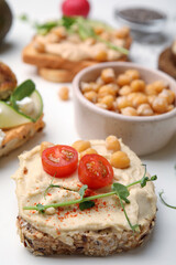 Fototapeta na wymiar Delicious sandwiches with hummus and ingredients on white table